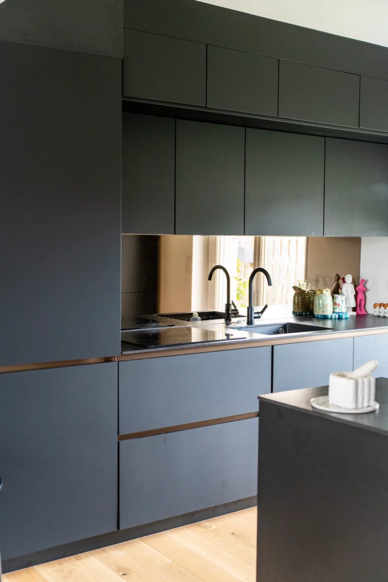 Rénovation de cuisine contemporaine avec meubles noirs et plan de travail design