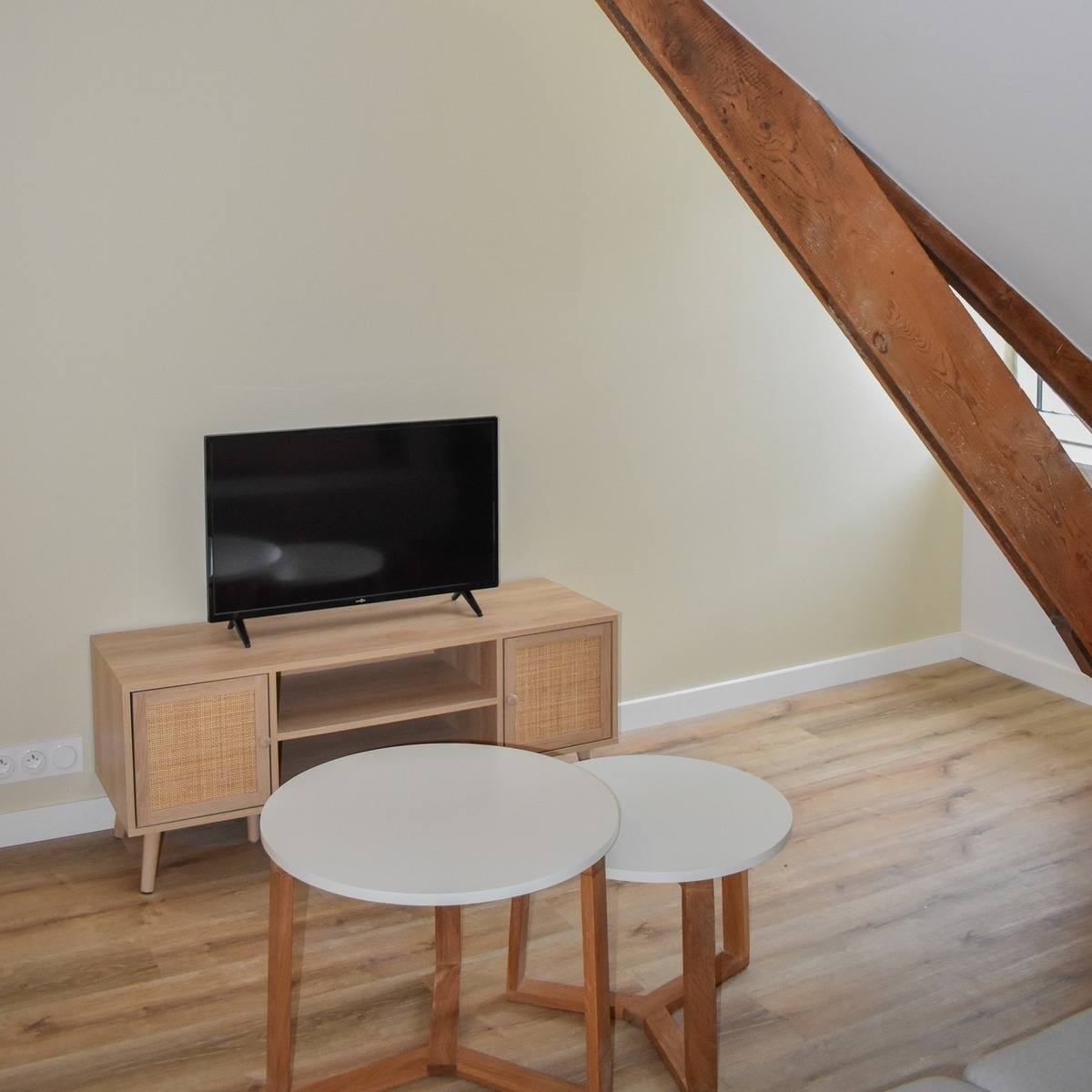 Aménagement d’un coin TV fonctionnel dans un salon sous pente.