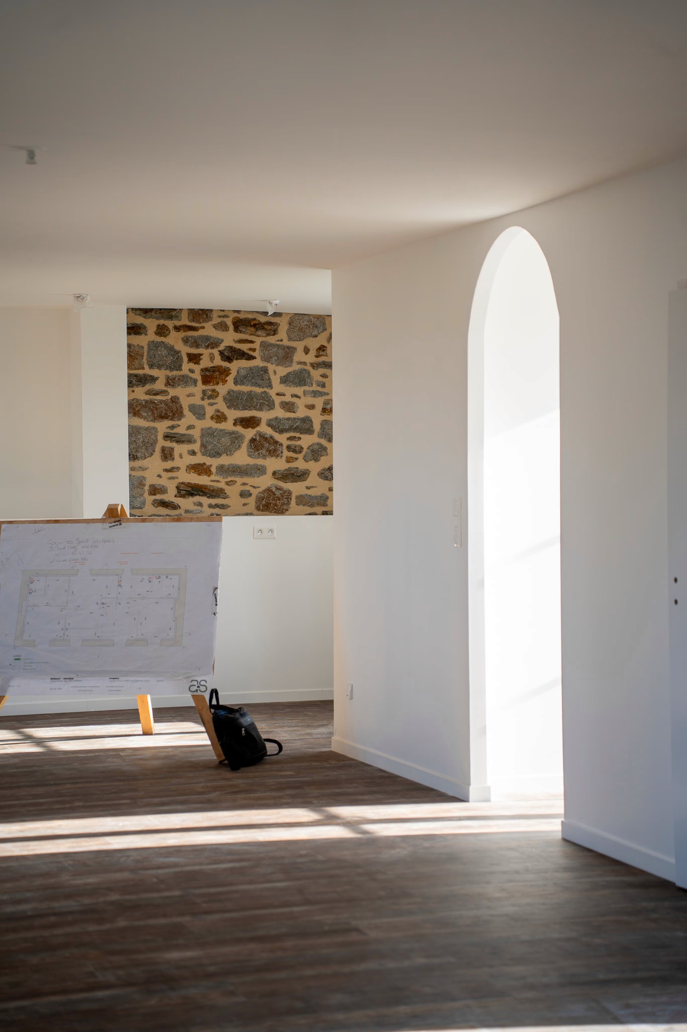 Projet de rénovation complète d’un intérieur avec modernisation des sols et mise en valeur des murs anciens.