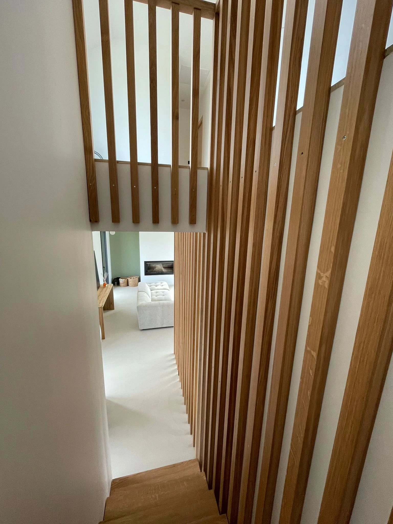 Claustra en bois installé le long d’un escalier dans une maison rénovée.