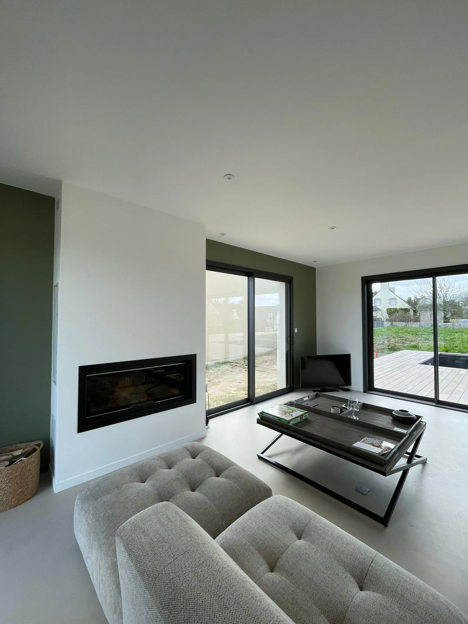 Pièce de vie rénovée avec cheminée intégrée, salon contemporain et accès direct à la terrasse.